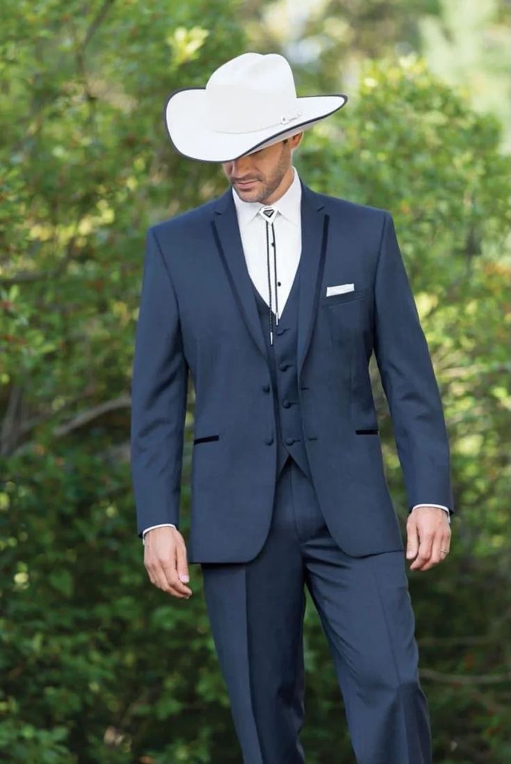 Novio con traje azul y sombrero vaquero blanco