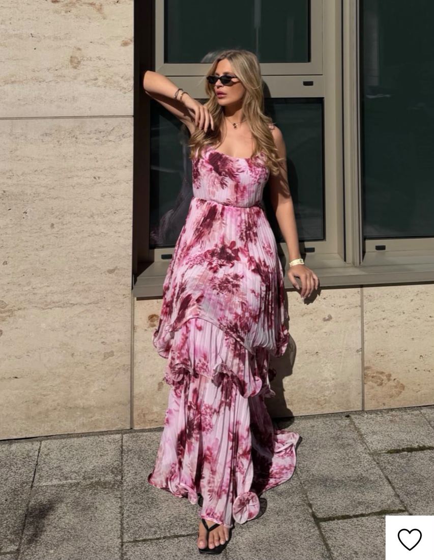 Vestido rosa con holanes junto a un muro de piedra